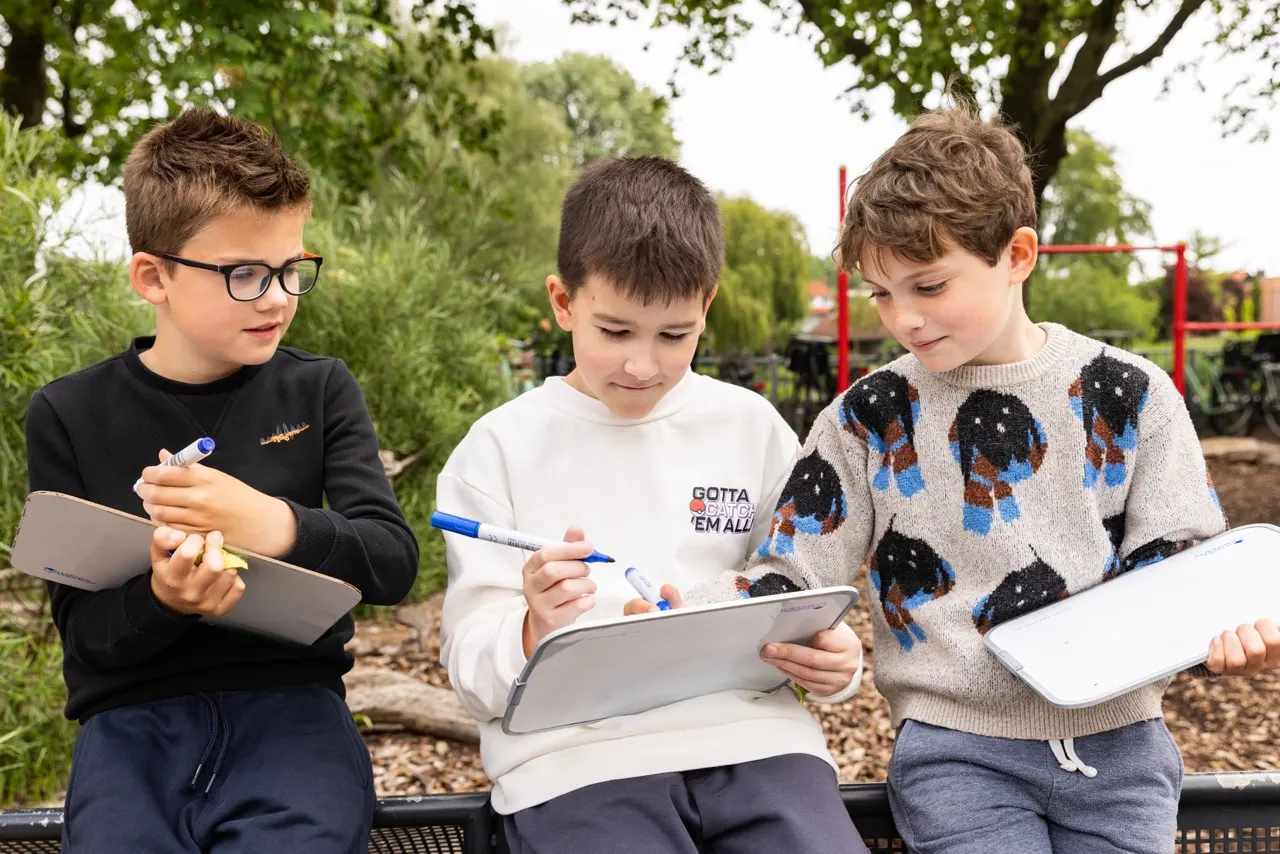 Drie jongens met wisbordjes op het plein