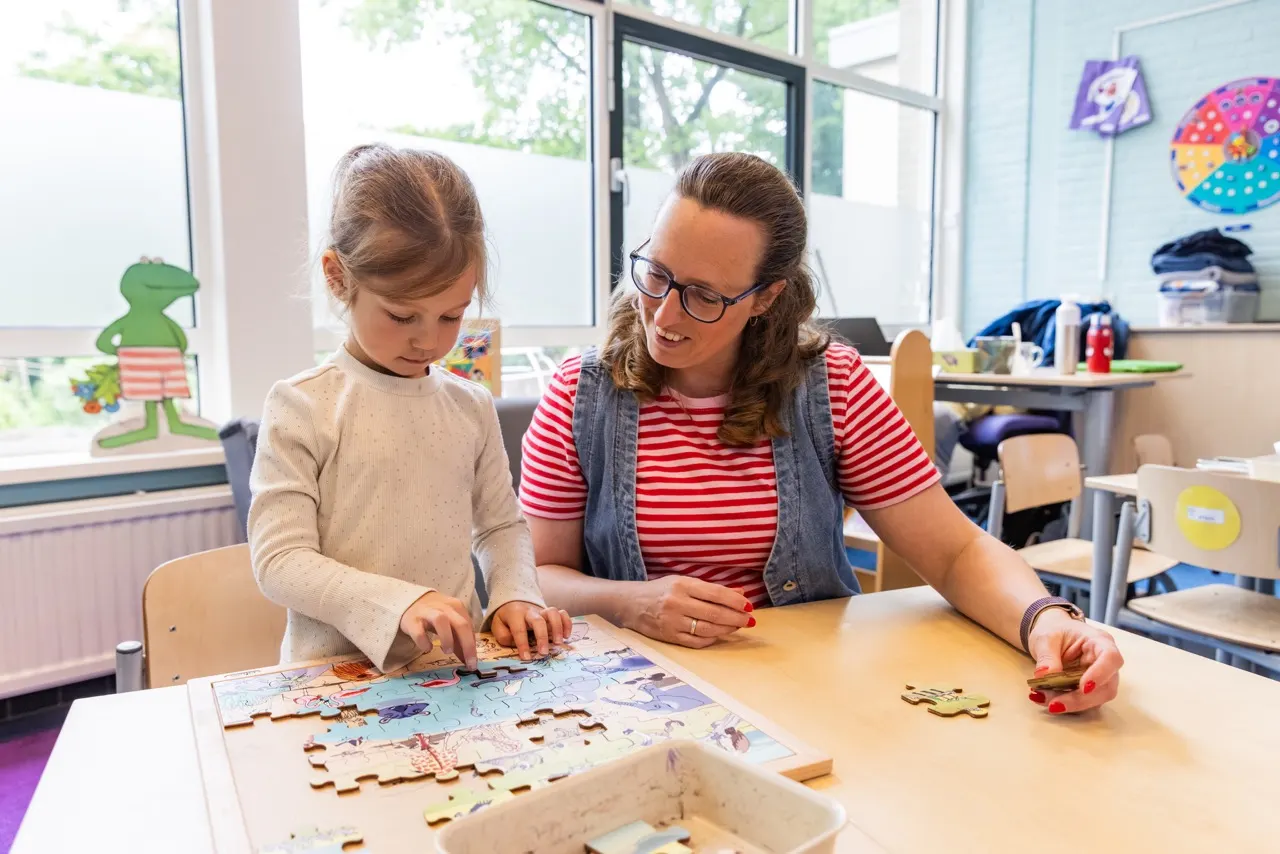 Leerling en leerkracht maken puzzel